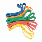 Stack of colorful resistance loop bands in blue, orange, green, red, and yellow, fanned out on a white background.