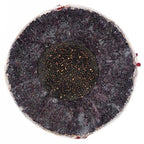 A cross-section of a Rawlings Pony League baseball showing a dark, speckled core surrounded by a thick, fibrous layer.