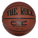 The Rock 29.5" basketball featuring C2C technology, deep pebble channels, and NFHS branding on a brown leather surface.