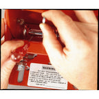 Close-up view of a red Bison Elite Breakaway Goal showing a hand adjusting the internal spring mechanism with a screwdriver.