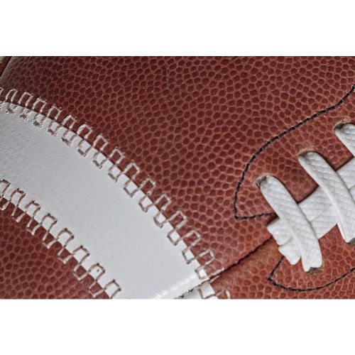 Close-up of a brown Spalding Alpha football featuring a white stripe and white laces.