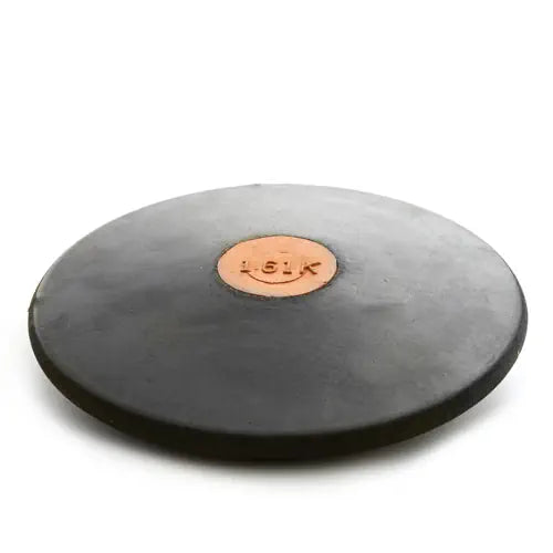 A black rubber Nelco discus with a central copper-colored plate marked "1.61K," shown from a low-angle perspective.